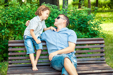 Image showing Father and son playing at the park on bench at the day time.