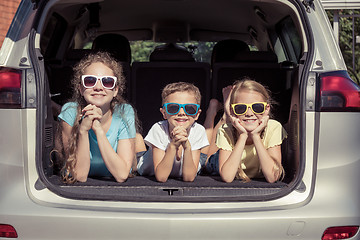 Image showing Happy brother and his two sisters are sitting in the car at the 