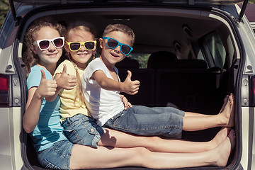 Image showing Happy brother and his two sisters are sitting in the car at the 
