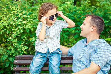 Image showing Father and son playing at the park on bench at the day time.