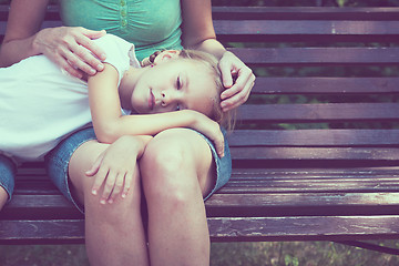 Image showing Sad mother and daughter sitting on bench in the park