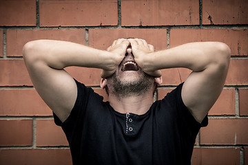 Image showing portrait one sad man standing near a wall