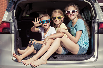 Image showing Happy brother and his two sisters are sitting in the car at the 