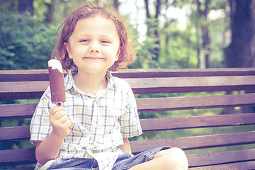 Image showing little boy eating ice cream in the park