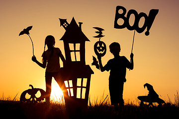 Image showing Happy brother and  sister playing outdoors at the sunset time.