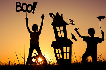 Image showing Happy brother and  sister playing outdoors at the sunset time.