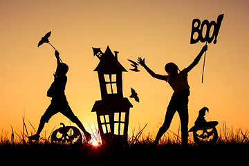 Image showing Happy brother and  sister playing outdoors at the sunset time.