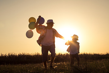 Image showing Father and son running on the road at the sunset time.