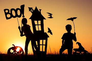 Image showing Happy brother and  sister playing outdoors at the sunset time.