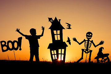 Image showing Happy little boy playing outdoors at the sunset time.