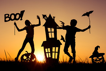 Image showing Happy brother and  sister playing outdoors at the sunset time.