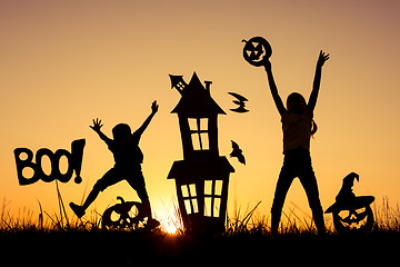 Image showing Happy brother and  sister playing outdoors at the sunset time.