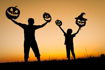 Image showing Happy father and son playing outdoors at the sunset time.