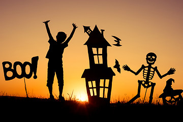 Image showing Happy little boy playing outdoors at the sunset time.