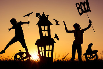 Image showing Happy brother and  sister playing outdoors at the sunset time.