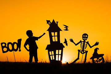 Image showing Happy little boy playing outdoors at the sunset time.