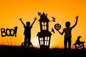 Image showing Happy brother and  sister playing outdoors at the sunset time.