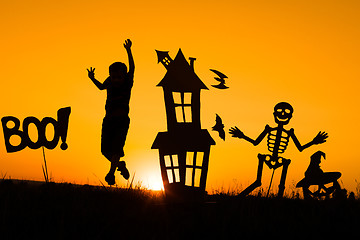 Image showing Happy little boy playing outdoors at the sunset time.