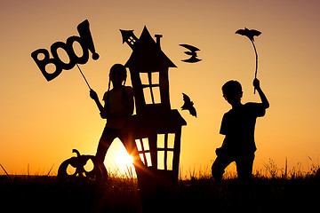 Image showing Happy brother and  sister playing outdoors at the sunset time.