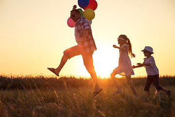 Image showing Father and children running on the road at the day time.