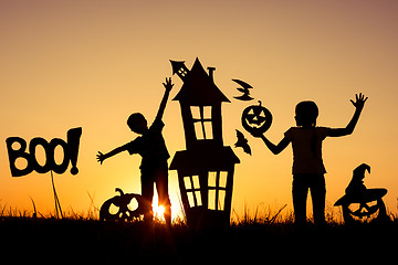 Image showing Happy brother and  sister playing outdoors at the sunset time.