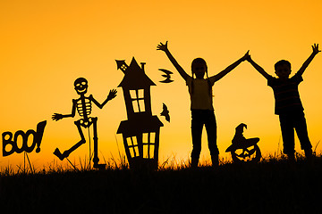 Image showing Happy brother and  sister playing outdoors at the sunset time.