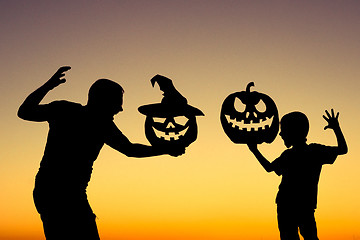 Image showing Happy father and son playing outdoors at the sunset time.