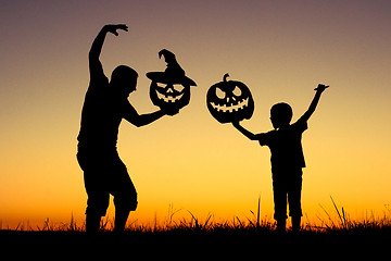 Image showing Happy father and son playing outdoors at the sunset time.