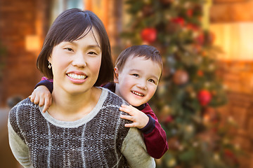 Image showing Chinese Mother and Mixed Race Child Inside House In Front of Dec