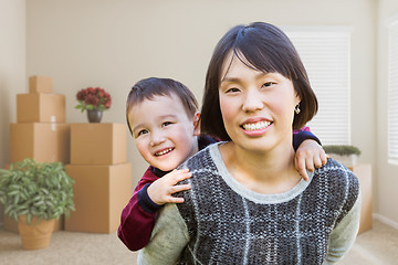 Image showing Chinese Mother and Mixed Race Child Inside Empty Room with Movin