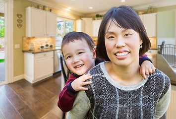 Image showing Chinese Mother and Mixed Race Child Inside Beautiful Kitchen.