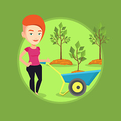 Image showing Woman pushing wheelbarrow with plant.