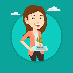 Image showing Woman holding plant growing in plastic bottle.