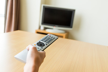 Image showing Watching TV and using remote controller