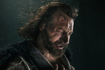 Image showing Portrait of a brutal bald-headed viking in a battle mail posing against a black background.