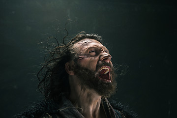 Image showing Portrait of a brutal bald-headed viking in a battle mail posing against a black background.