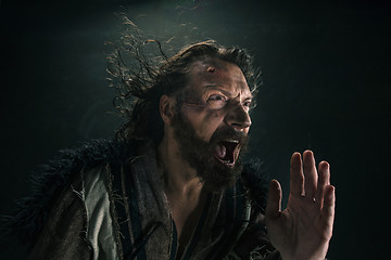 Image showing Portrait of a brutal bald-headed viking in a battle mail posing against a black background.