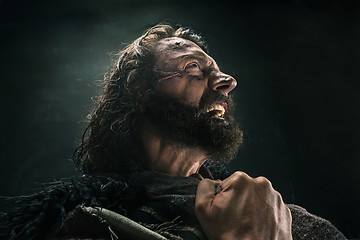 Image showing Portrait of a brutal bald-headed viking in a battle mail posing against a black background.