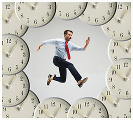 Image showing Businessman running over alarm clock.