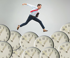 Image showing Businessman running over alarm clock.