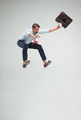 Image showing Businessman running with a briefcase, isolated on gray background