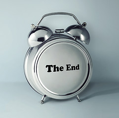 Image showing The conceptual image of alarm clock with word THE END on gray studio background