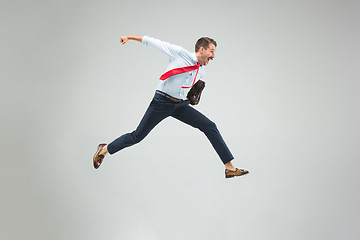 Image showing Businessman running with a briefcase, isolated on gray background