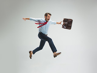 Image showing Businessman running with a briefcase, isolated on gray background