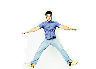 Image showing young pretty asian man jumping cheerful against white background