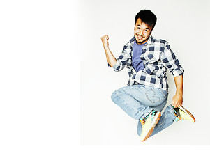 Image showing young pretty asian man jumping cheerful against white background