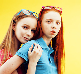 Image showing lifestyle people concept: two pretty young school teenage girls having fun happy smiling on yellow background 