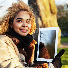 Image showing young cute blond african american girl student holding tablet an