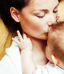 Image showing young brunette happy mother holding toddler baby son, breast-fee