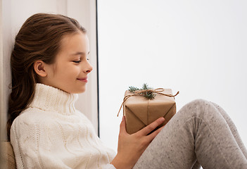 Image showing girl with christmas gift sitting at home